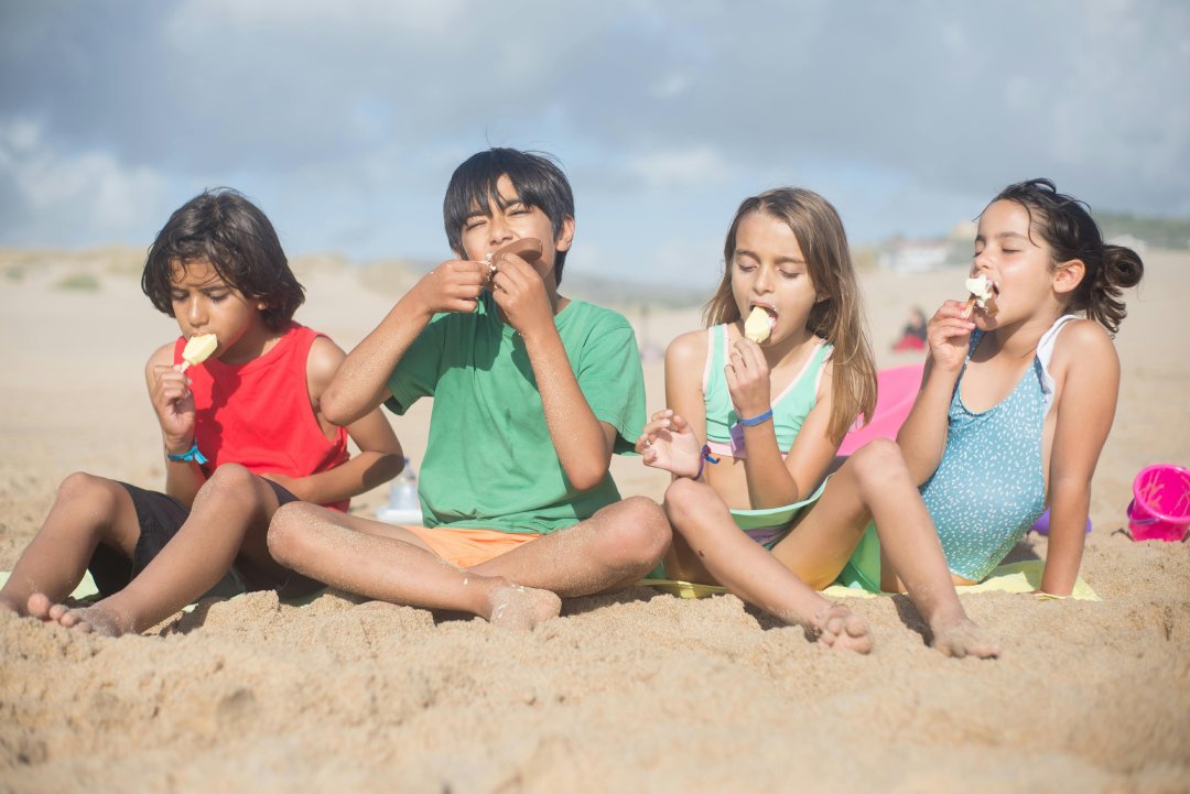 Four children sitting on the beach